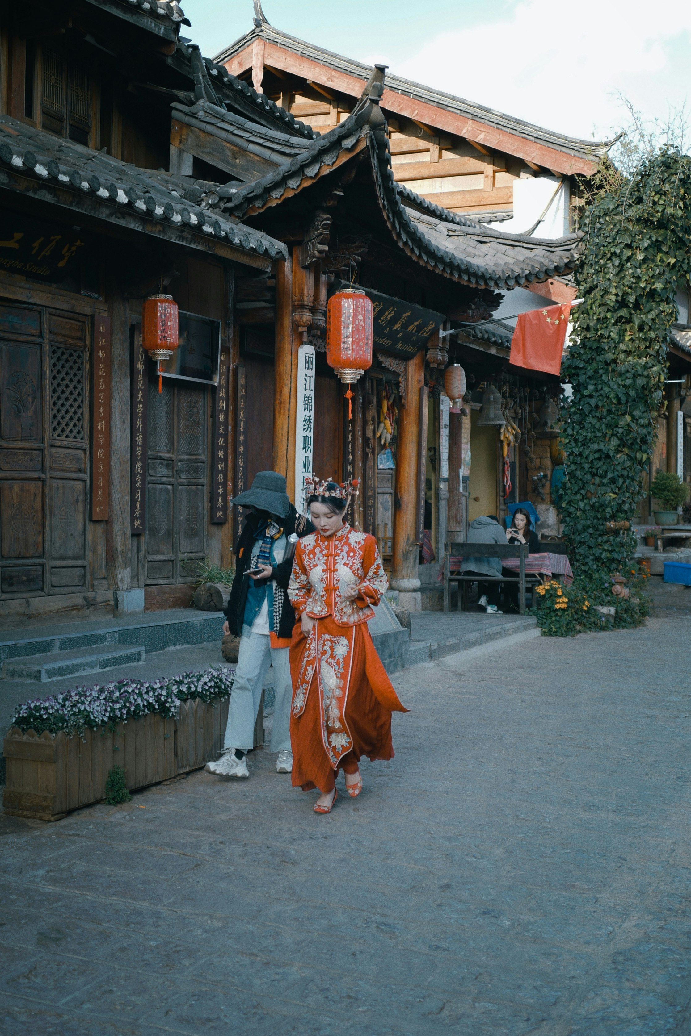 woman in orange and white dress walking on sidewalk during daytime